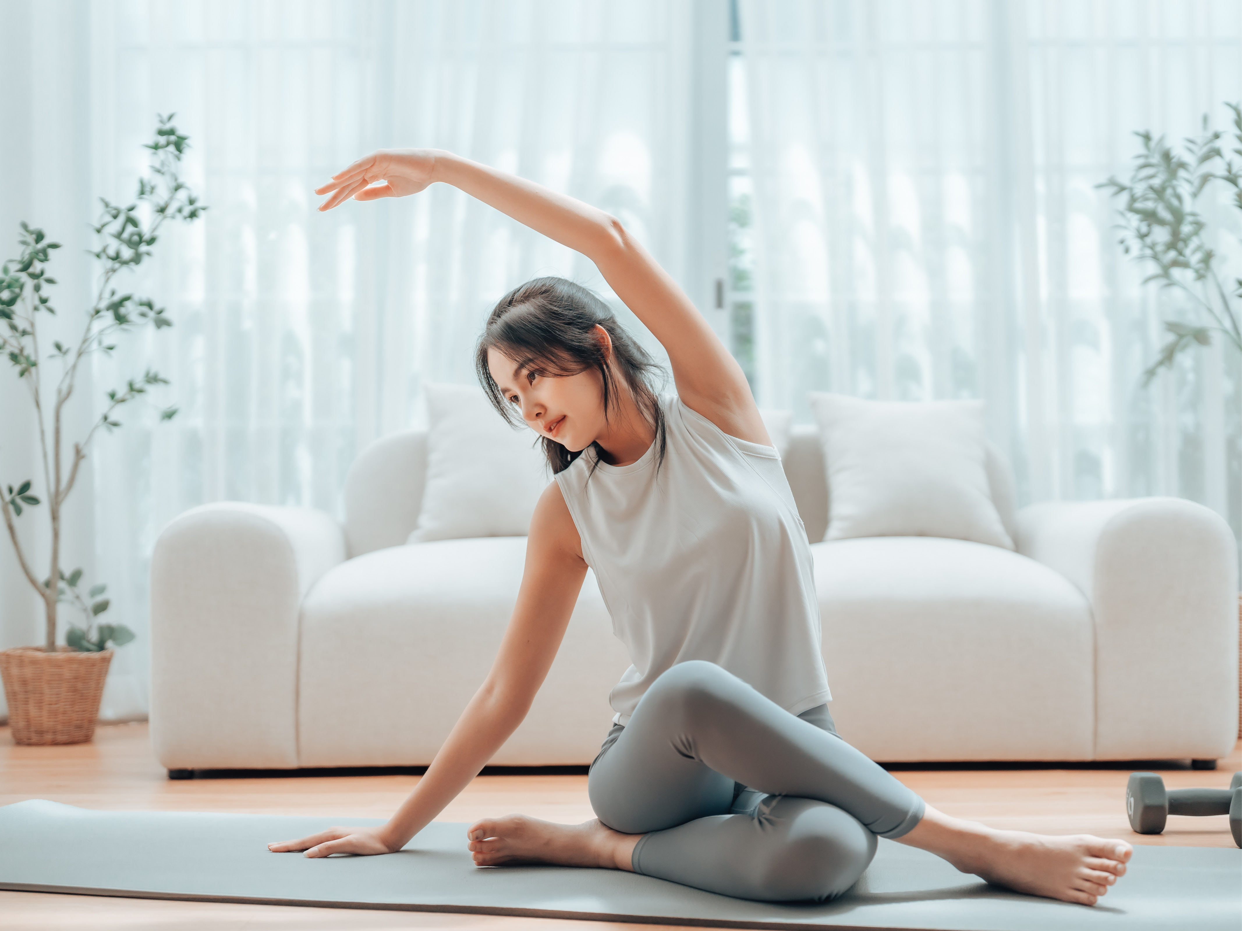 Junge Frau praktiziert Yoga auf einer Matte