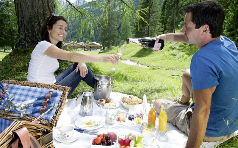 Ein Paar genießt ein Picknick im Almwellness-Resort Tuffbad