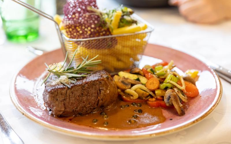 Rinderfiletsteak mit Beilagen und Dekoration im Restaurant des Hotels Kirchheimerhof
