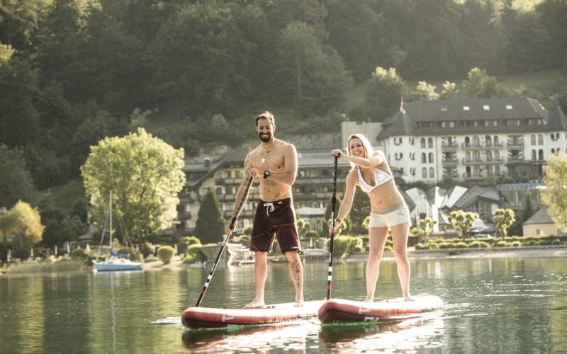 Zwei Gäste beim Standup-Paddling auf dem Fuschlsee vor dem Waldhof Fuschlsee Resort