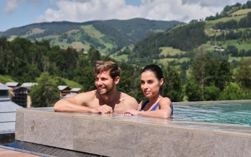 Ein Paar genießt den Aussenpool im Sporthotel Wagrain