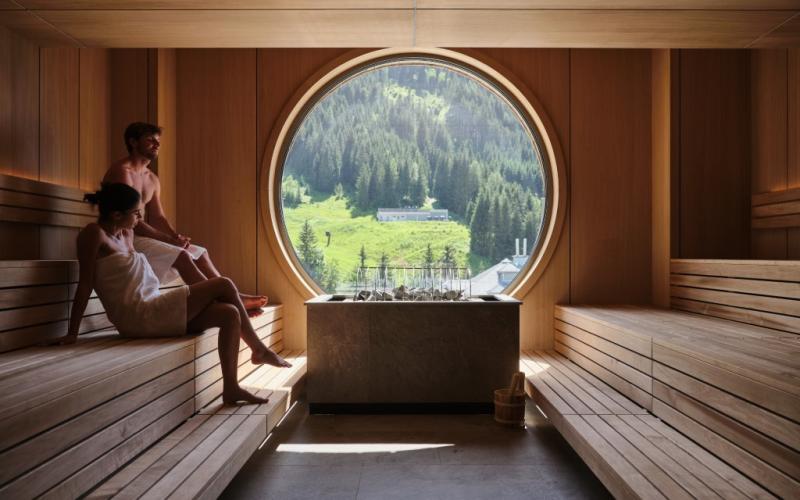 Zwei Gäste in der Sauna mit Ausblick im Sporthotel Wagrain