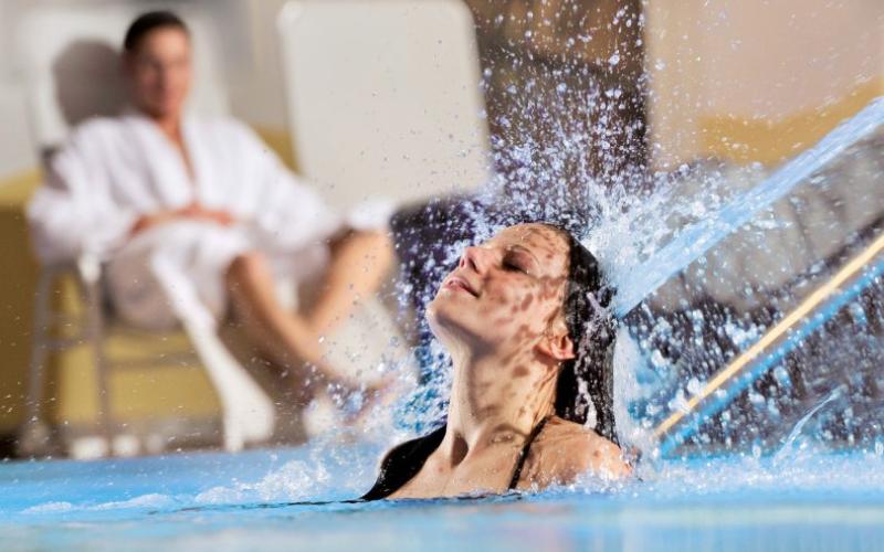 Zwei Gäste genießen den Innenpool des Hotels Almesberger