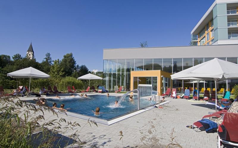 Blick auf den Aussenpool und die Kirche im Hintergrund des Gesundheitsresorts Lebensquell Bad Zell