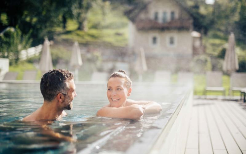 Zwei Gäste im Outdoor-Pool des DAS WALCHSEE Sportresorts