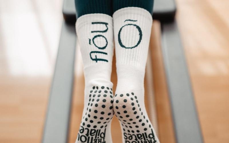 Beine in The Flou - Socken auf dem Pilates Reformer