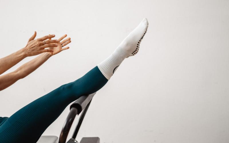 Pilates Reformer mit einer Kundin in der Boot-Position