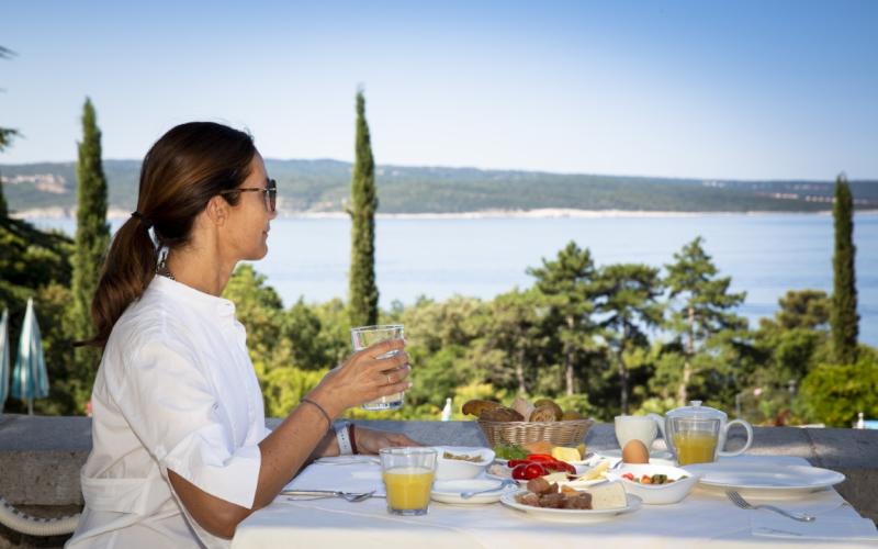 Hotel Kvarner Palace Eine Dame genießt das Frühstück im Hotel Kvarner Palace mit Blick aufs Meer
