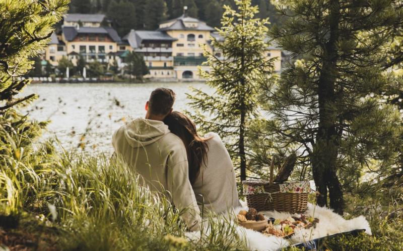 Ein Paar beim Picknick gegenüber vom Seehotel Jägerwirt