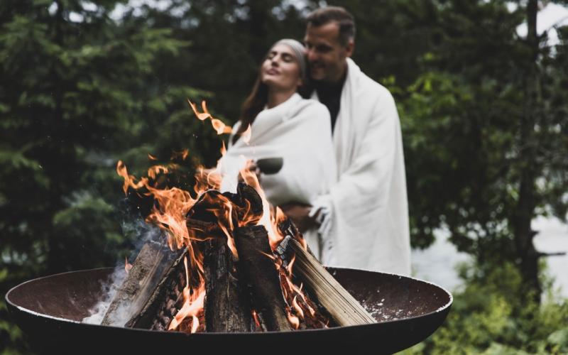 Paar im Bademantel bei einer Feuerschale im Seehotel Jägerwirt