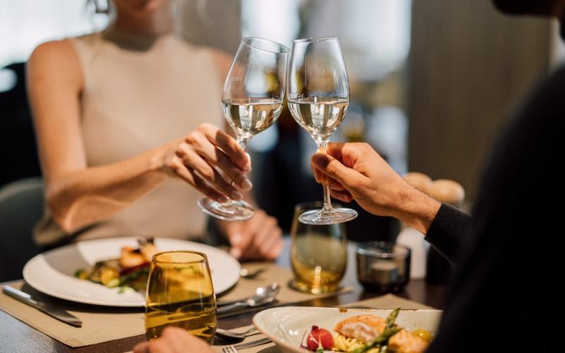 Zwei Gäste beim Abendessen mit einem Glas Wein im Restaurant des Spa Resort Geinberg