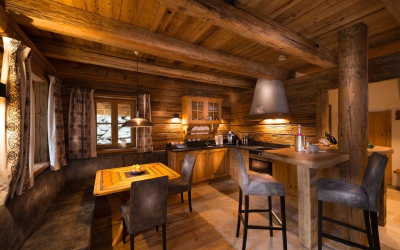 Küche und Wohnbereich in einem rustikalen Chalet im Chaletdorf Auszeit ganz in Holzoptik gehalten