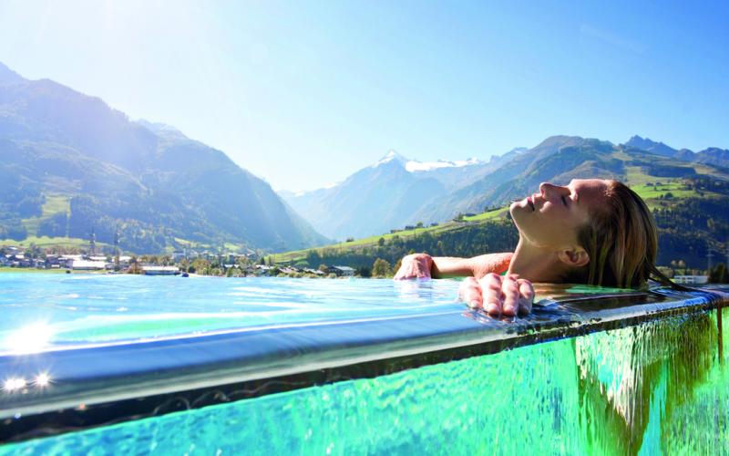 Eine Dame liegt im Pool im Tauern SPA Zell am See