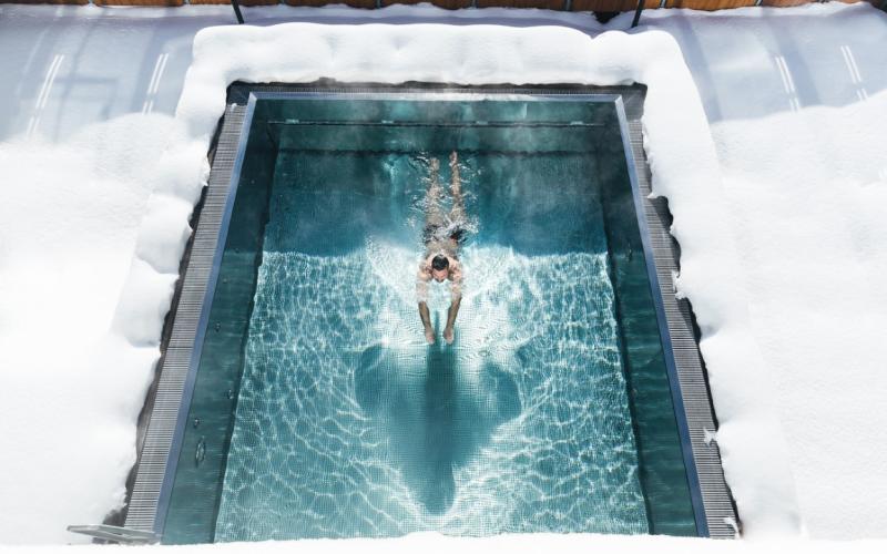 Beheizter Aussenpool im Winter mit einem Gast im Hotel Klausnerhof