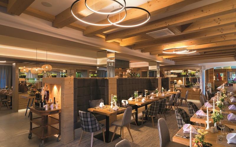 Blick in das modern gestaltete Restaurant mit gedeckten Tischen im Aktivhotel Alpendorf