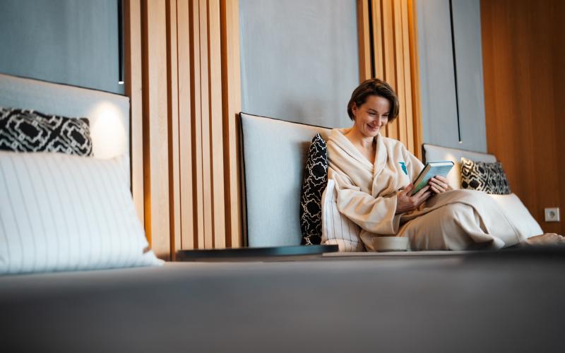 Eine Dame mit Buch im Ruheraum des Hotels der daberer. das biohotel