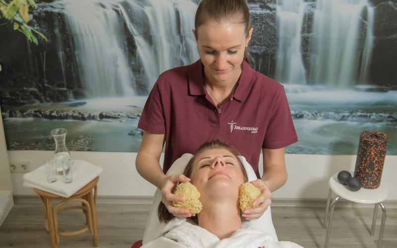 Eine Dame genießt eine Behandlung durch eine Therapeutin im Johannesbad Hotel Palace