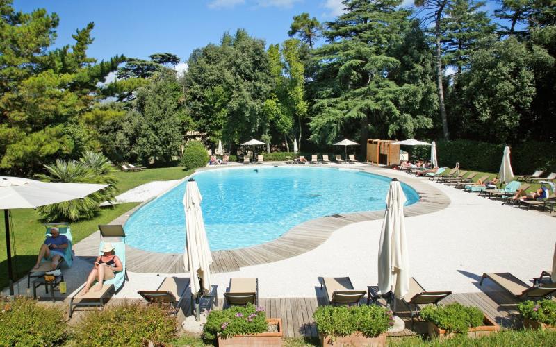 Schwimmbad aussen im Borgo di Colleoli Resort mit Liegen und Gästen