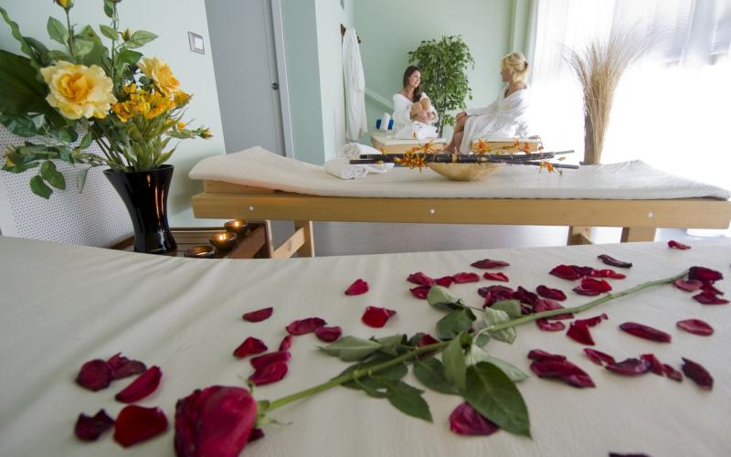 Ein Doppelbett mit roten Rosenblättern dekoriert im Grand Hotel Astoria