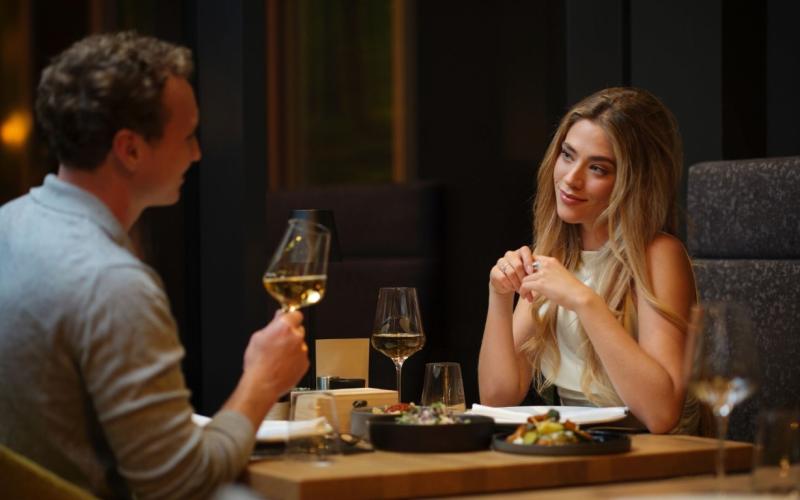 Impulshotel Freigold - Paar am Abend beim Abendessen mit einem Glas Wein