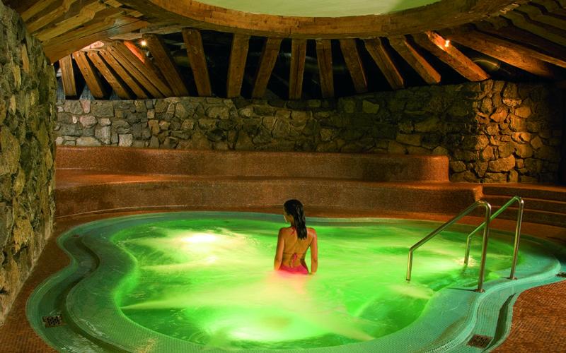 Eine Dame im Whirlpool mit grüner Beleuchtung im Traumhotel ... liebes Rot-Flüh