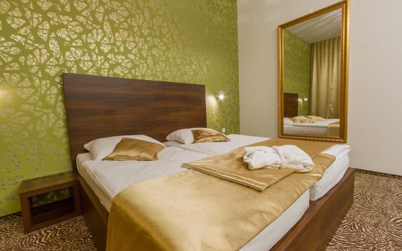 Doppelzimmer mit goldenen Akzenten und hellgrüner Tapete im Rimske Terme Hotel Rimski dvor