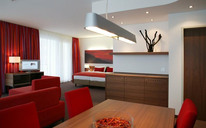 Beispeil eines Doppelzimmers in rot mit Ess- und Schlafbereich im Gesundheitsresort Lebensquell Bad Zell