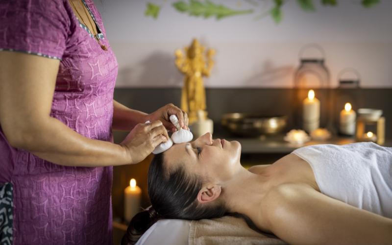 Eine Dame bei der Kräuterstempel-Behandlung im JUFA Hotel Stift Gurk