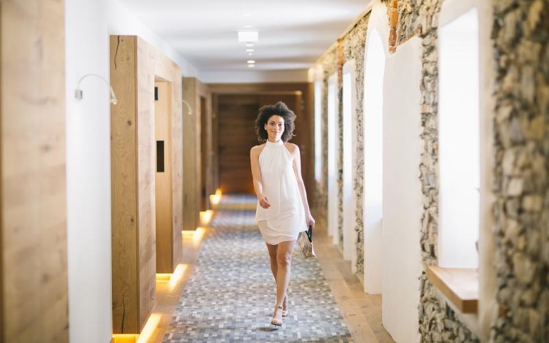 Eine Dame am Gang zum Wellnessbereich im Hotel Klosterbräu und Spa