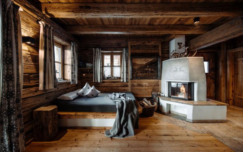 Blick in ein Doppelzimmer in einem Chalet mit offenem Kamin im Chaletdorf Auszeit