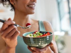 Junge Frau isst einen Obstsalat