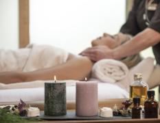 Eine Dame genießt eine Nackenmassage im Wellnessbereich des Waldhof Fuschlsee Resort