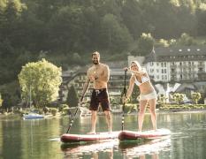 Zwei Gäste beim Standup-Paddling auf dem Fuschlsee vor dem Waldhof Fuschlsee Resort