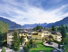 Aussenansicht des Hotels Hollweger mit Wolfgangsee und Bergen im Hintergrund
