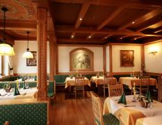 Blick in den Speisesaal im Landhausstil mit gedeckten Tischen im Landhotel Strasserwirt