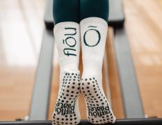 Beine in The Flou - Socken auf dem Pilates Reformer