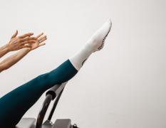 Pilates Reformer mit einer Kundin in der Boot-Position