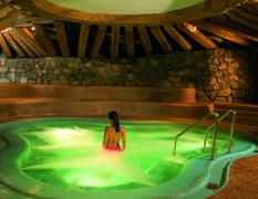 Eine Dame im Whirlpool mit grüner Beleuchtung im Traumhotel ... liebes Rot-Flüh