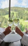Zwei Gäste im Bademantel prosten einander zu im Sporthotel Wagrain