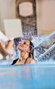 Zwei Gäste genießen den Innenpool des Hotels Almesberger