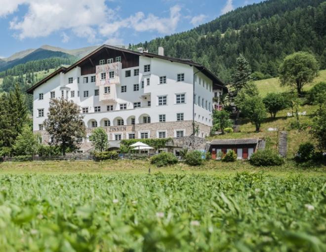 Frontalansicht des Hotels Drei Zinnen und der umliegenden Landschaft